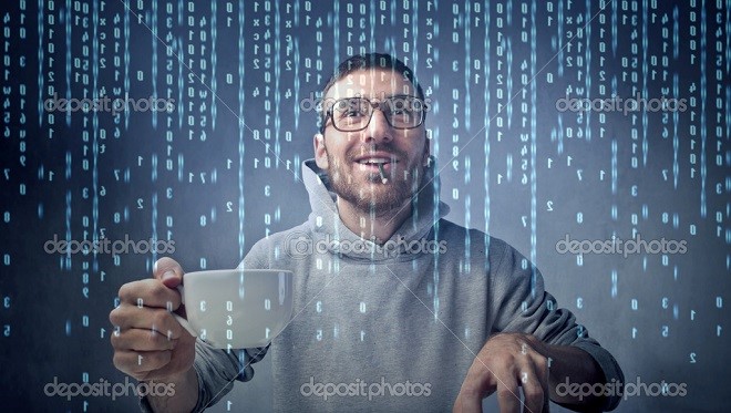 Young man sitting in front of a computer screen with binary code passing on the screen